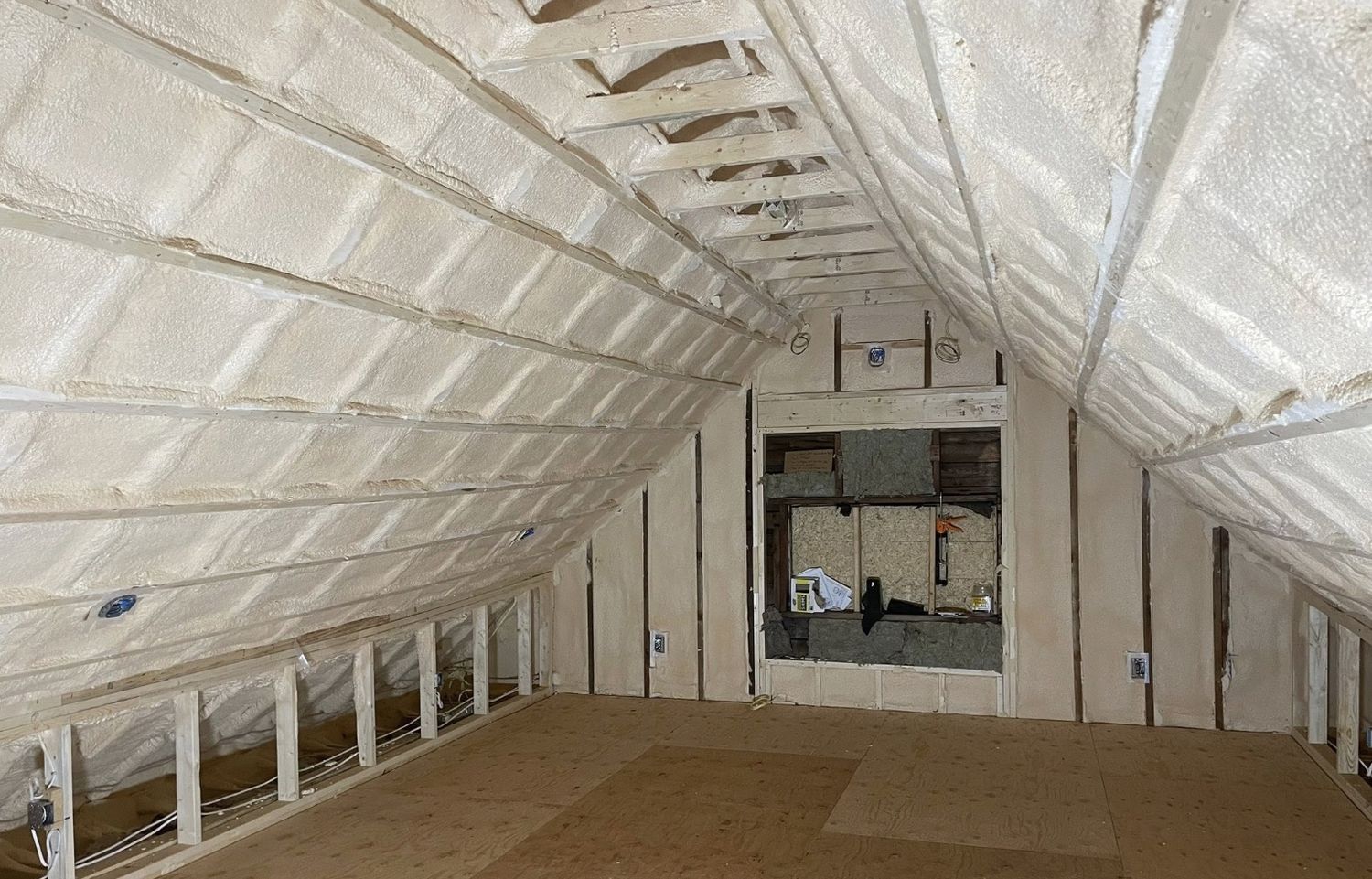 Attic conversion with roof slopes fully spray foamed between rafters