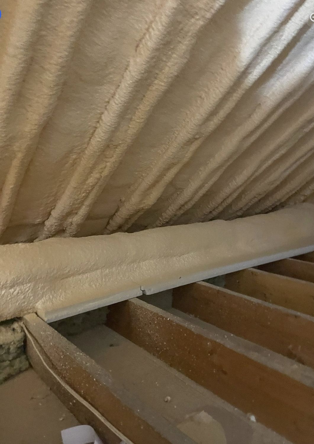 Full attic roof slope covered in spray foam from ridge to eave