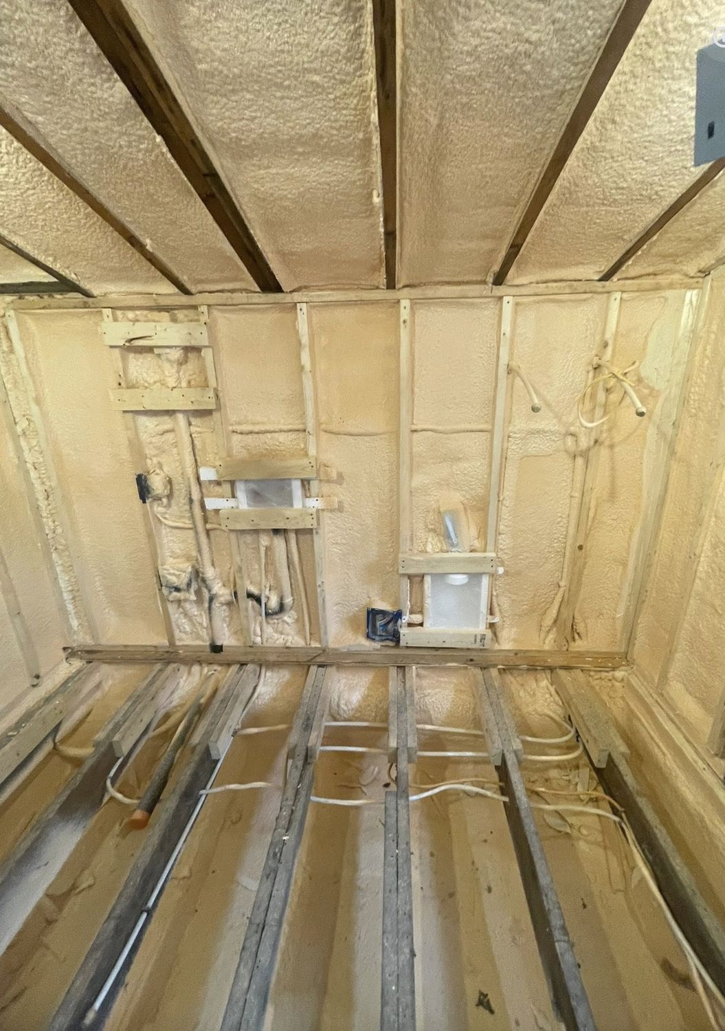 Renovated room with walls and ceiling fully spray foamed between studs and joists